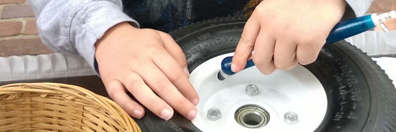 Child learning how to check tire pressure
