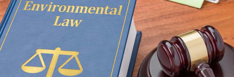 A book of environmental laws sits on a wooden desk
