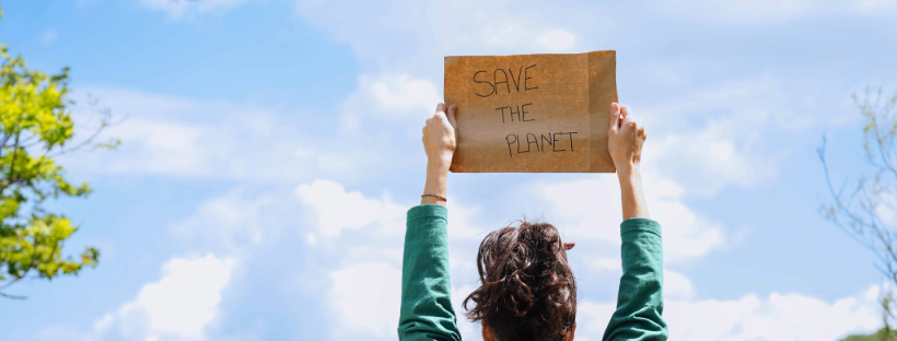 Woman holds sign that says "save the planet"