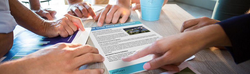 Human hands pointing to a DOW Fact Sheet on table