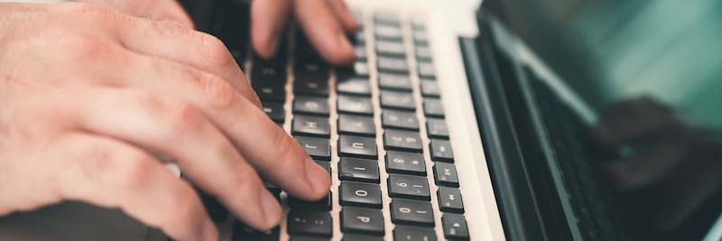 Mans hands typing on keyboard