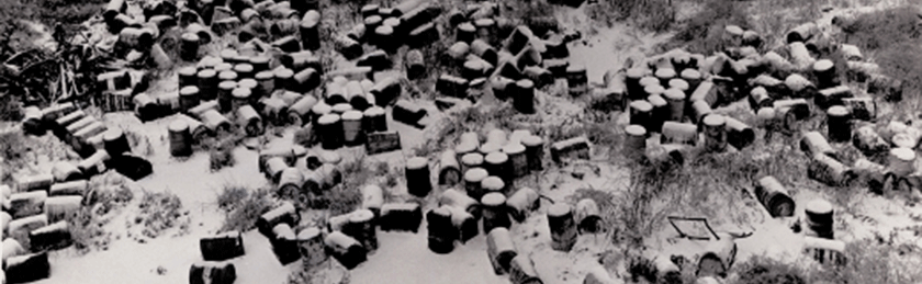 A valley filled with discarded drums of waste