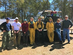 Prescribed fire staff, wearing yellow fire suits, posing for a photo.